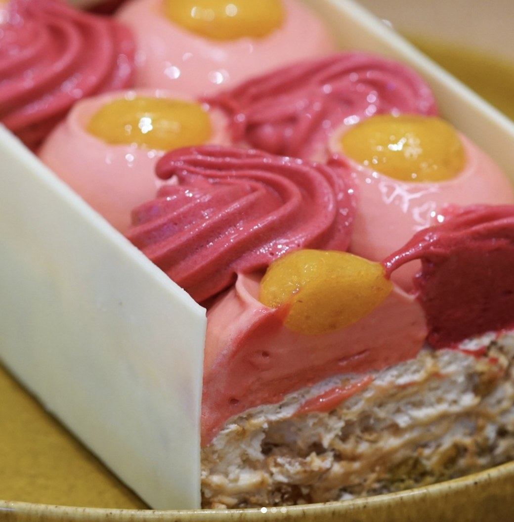 Dessert glacé rose et framboise, garni de coulis de fruits jaunes, vu en coupe